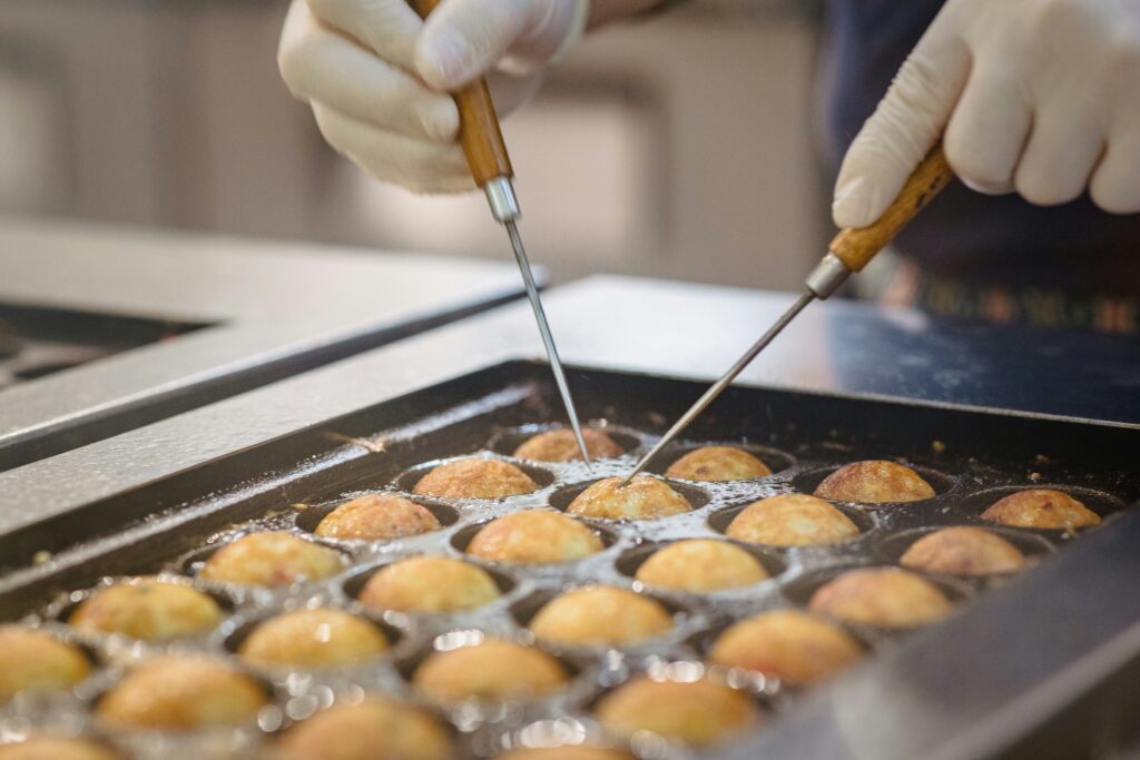 Fresh takoyaki being cooked at a street food stall